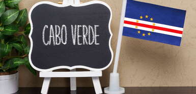 Tafel mit Schriftzug Cabo Verde und daneben eine Kapverden-Flagge