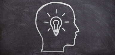 Kreidezeichnung auf Tafel - Umriss Kopf mit Glühbirne innerhalb